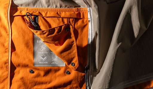Dettagli tecnici di una giacca della collezione Laboratorio di Cape Horn, con le qualità della tecnologia ripstop in evidenza: multi strato, wind resistant e water repellent. - Cape Horn